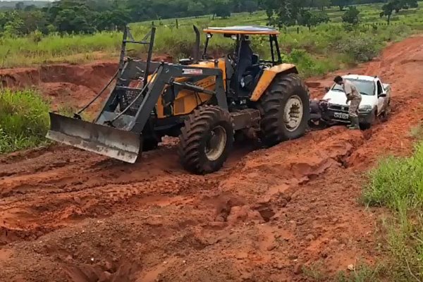 Imagem: Um trator tem auxiliado os motoristas que não conseguem passar pela rodovia devido aos buracos e lama.