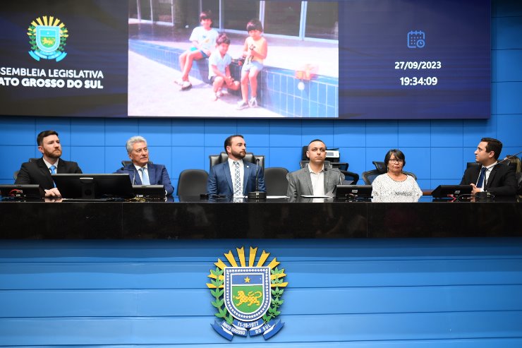 Imagem: Deputado João César Mattogrosso entrega flores à senhora Roselene Ribeiro, mãe de Anderson Barão, durante sessão solene desta noite