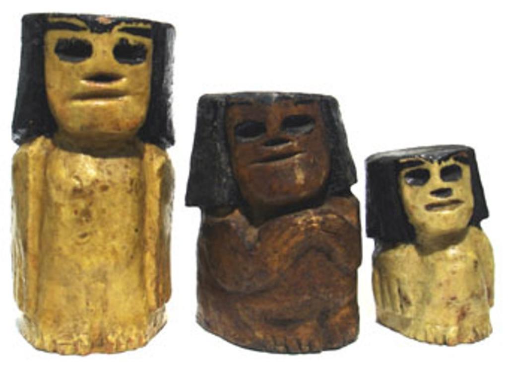 Imagem: Bugres esculpidos em madeira com golpes secos e retos de facão e recobertos com cera de abelha.